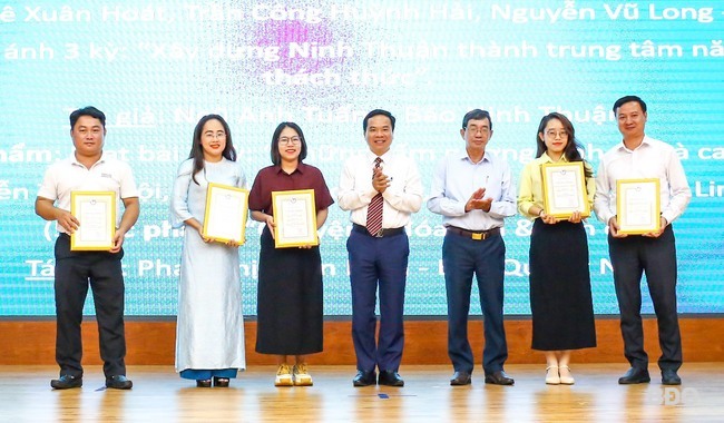 Đại diện nhóm tác giả Nguyễn Thị Muội, Đỗ Thị Thảo Khuy, Dương Ngọc Diệu Linh - Báo Bình Định (thứ 2 từ phải sang) nhận giải khuyến khích thể loại báo in, báo điện tử cho loạt bài 2 kỳ “Những tấm gương bình dị mà cao quý”. Ảnh: NGUYỄN DŨNG